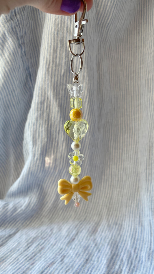Yellow beaded Bag Charm with heart, flower and bow charms